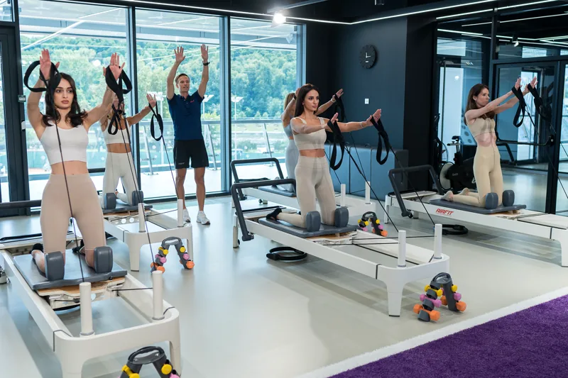 Групповое занятие пилатесом на реформере с ремнями в студии AirFit Лужники